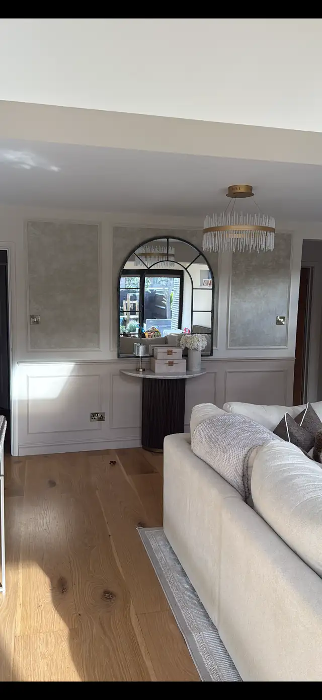 Living room with painted wall panelling and papered panels